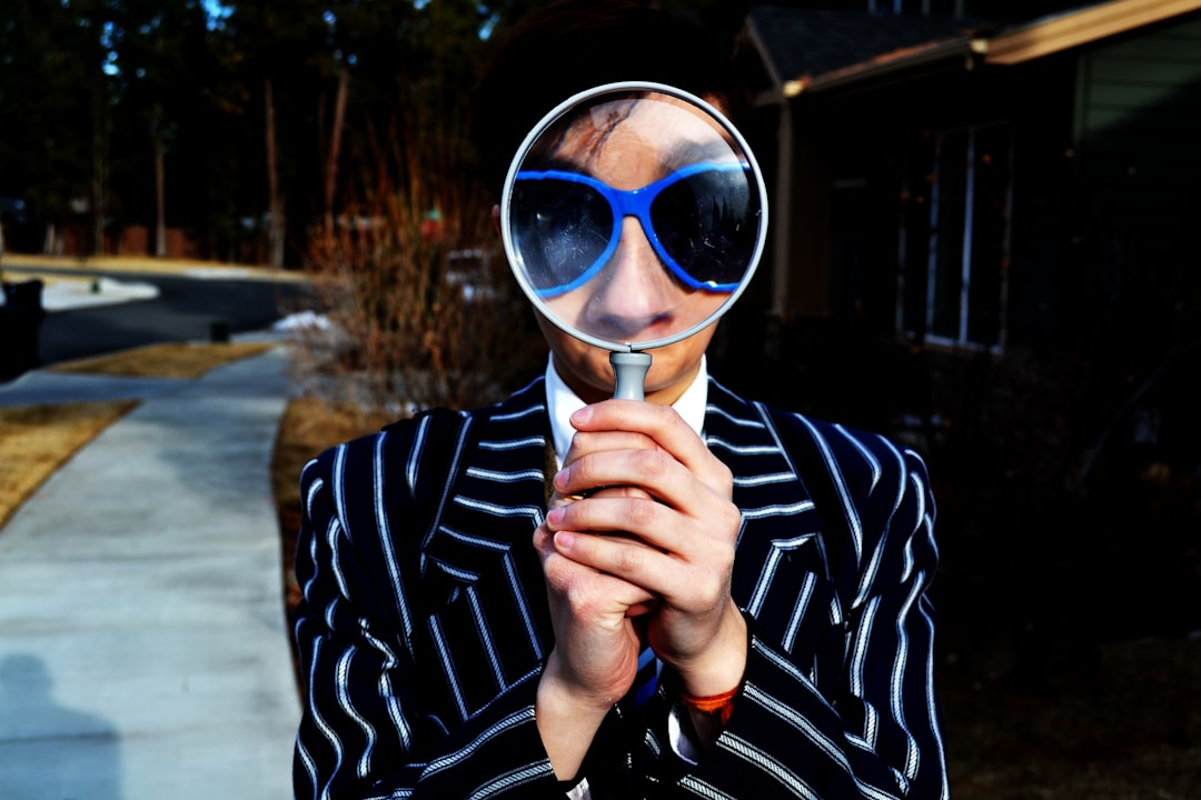 Photo by Marten Newhall person using magnifying glass enlarging the appearance of his nose and sunglasses